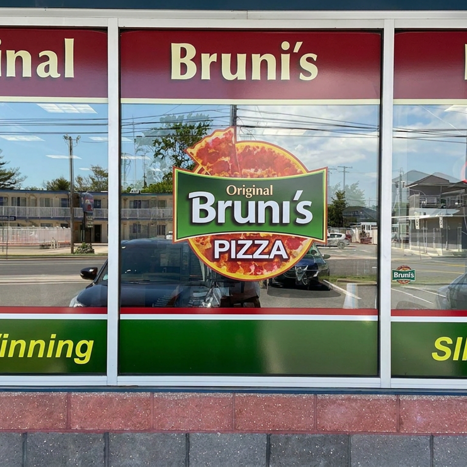 Original Bruni’s Pizza storefront displays award-winning pizza branding, an open sign, and reflections of the street outside.